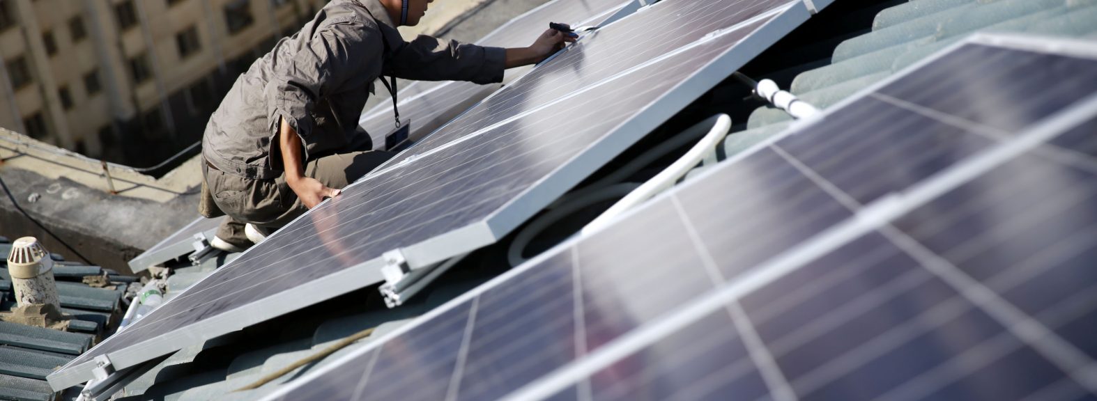 Installing solar panels on a rooftop in Jiujiang, East China